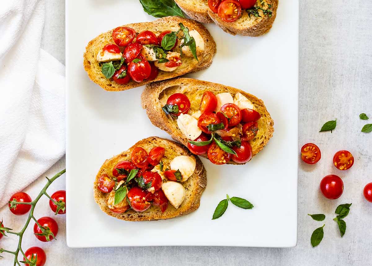 Toast slices topped with homemade bruschetta and mozzarella.