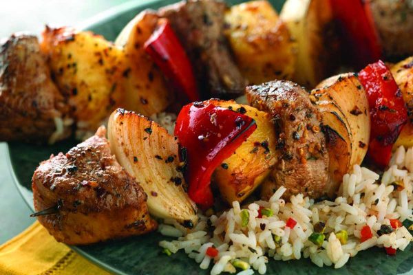 Pork kabobs with vegetables on rice.