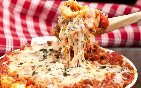 Spoon lifting cheesy beef tortellini.