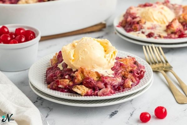 Cherry dump cake on a white plate with a fork.