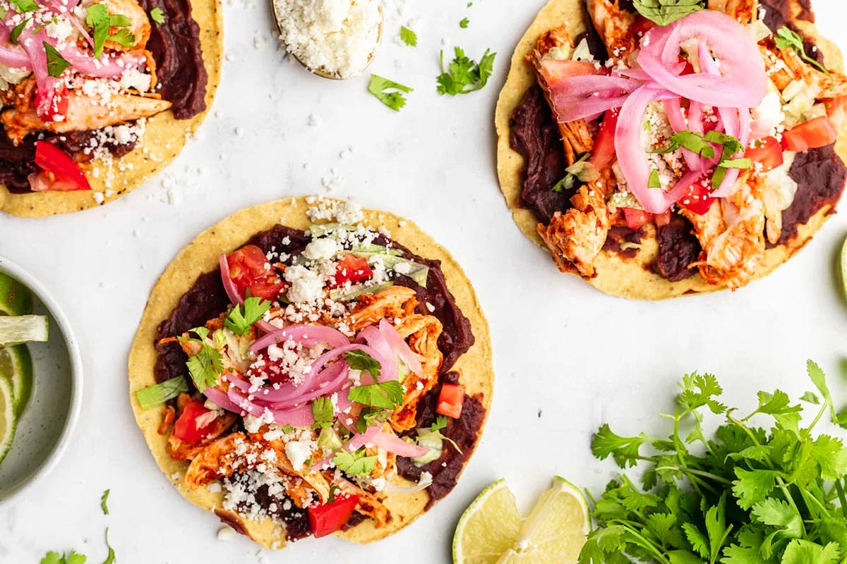 A tostada made of black beans, chili chicken and veggies.