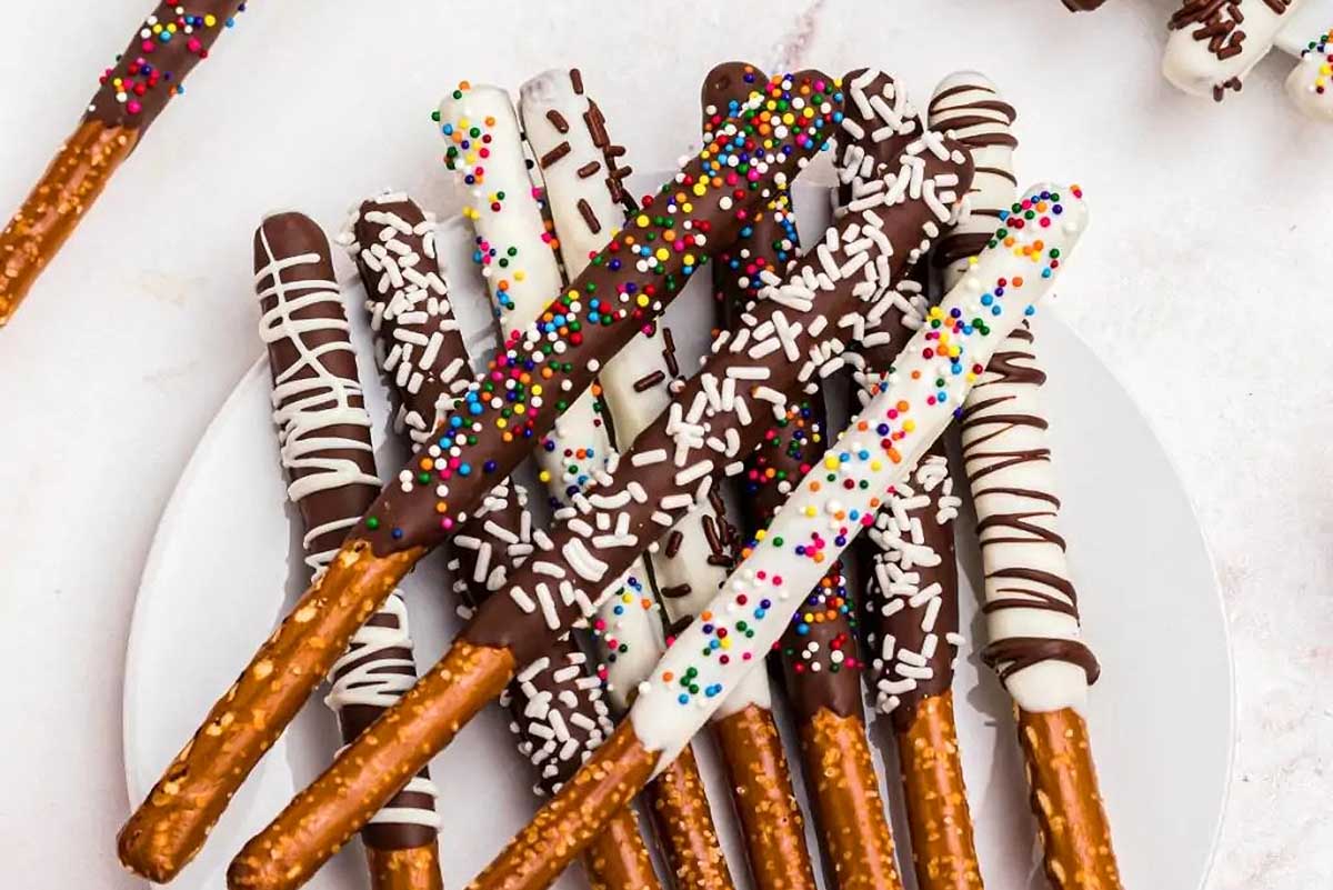 Pretzels stick with sprinkles on a white plate.