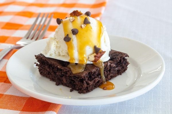 Slice of chocolate cake with ice cream on a plate.