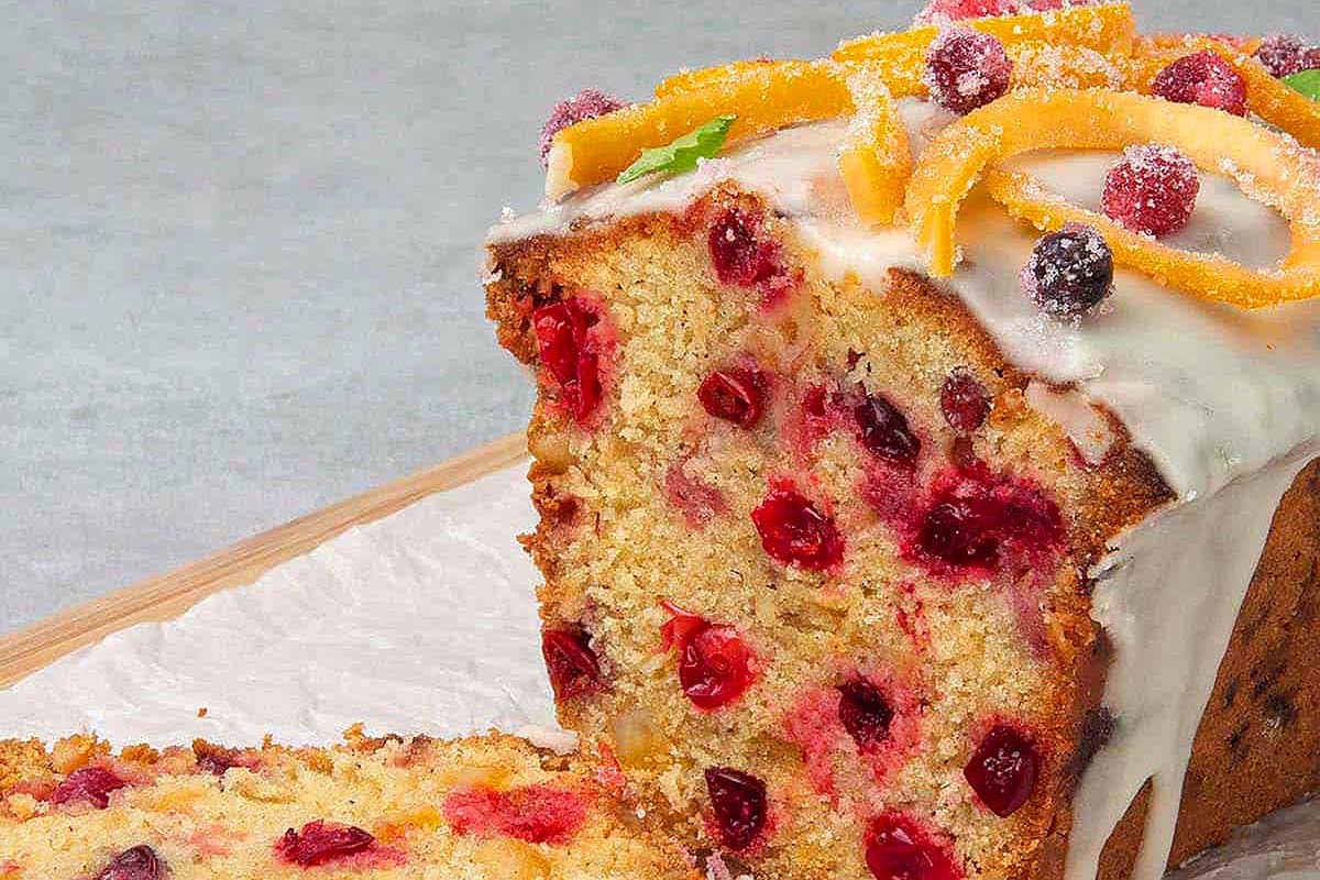 A slice of cranberry orange bread with icing.