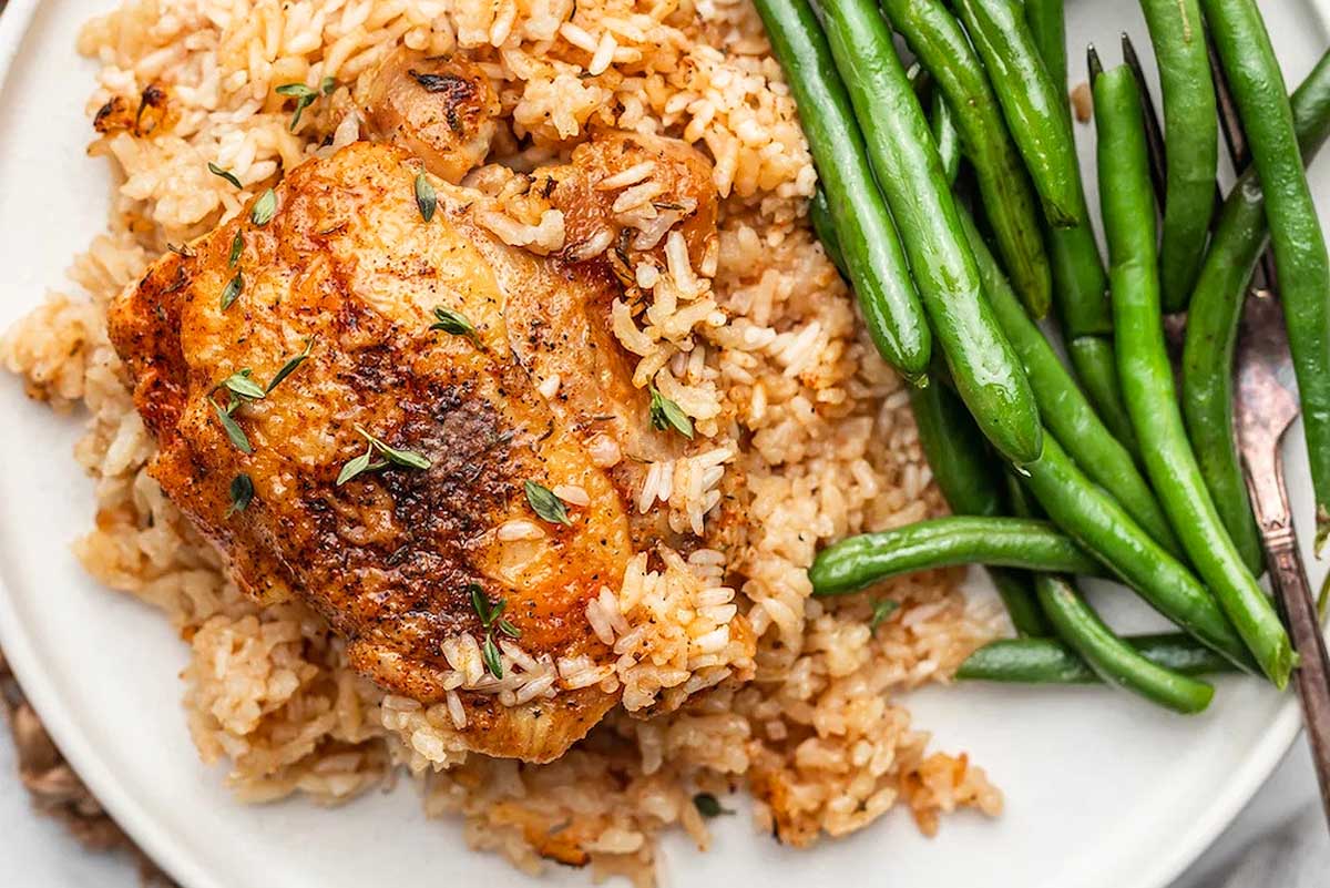 Chicken and rice served with green beans.