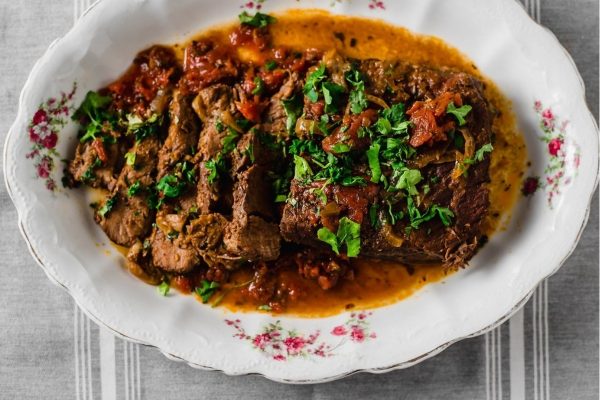 Cuban inspired brisket with sazon and chiles on a white serving dish.