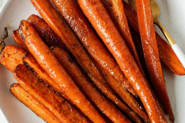 Carrots baked with a maple glaze and served on a white plate. 