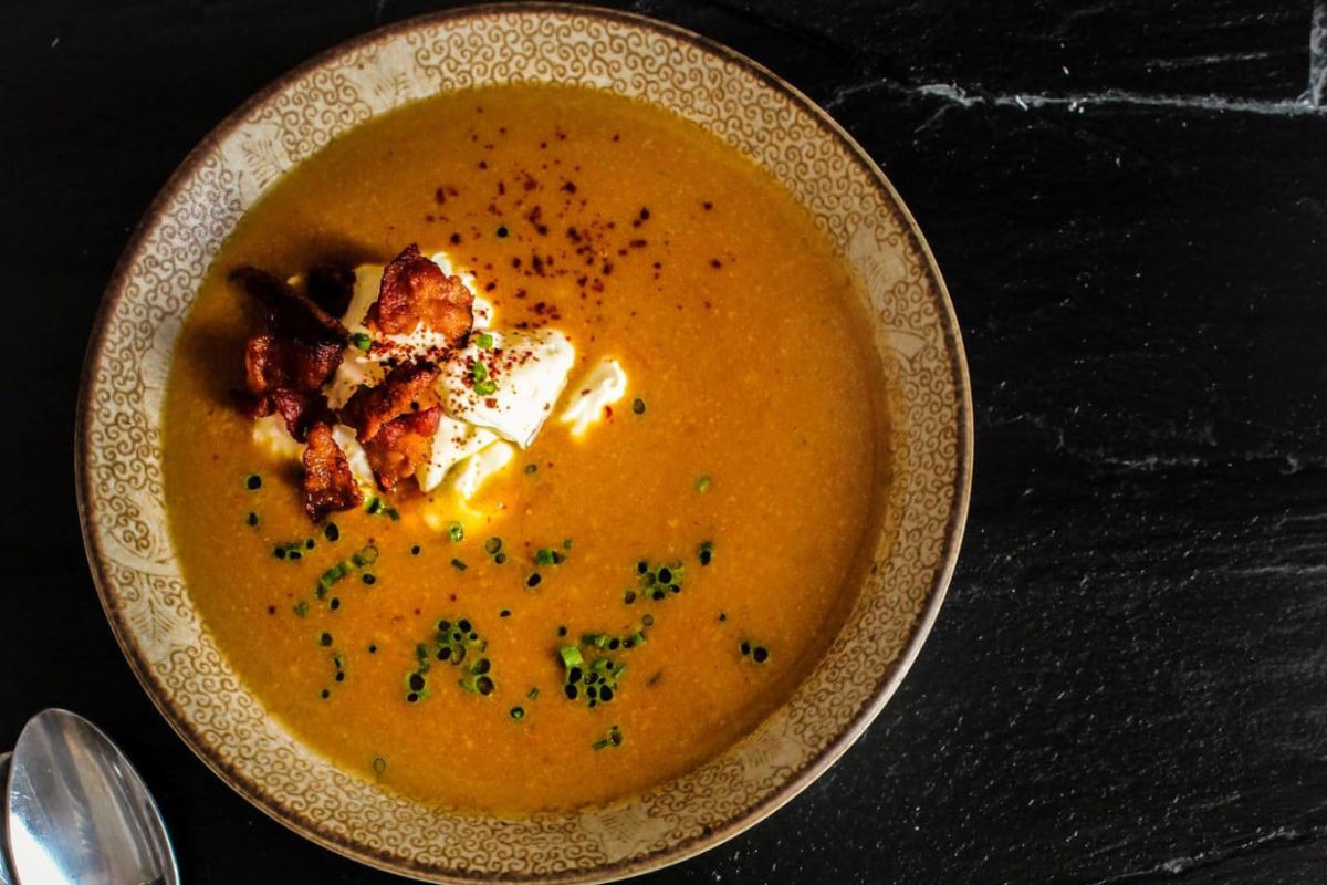 Easy Miso Pumpkin Soup in a bowl with cream and herbs