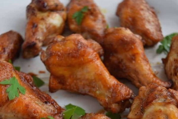 Bbq chicken wings on a white plate.