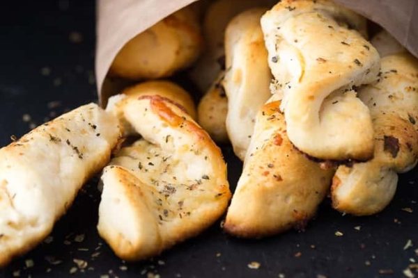 Garlic twists on a black plate. 