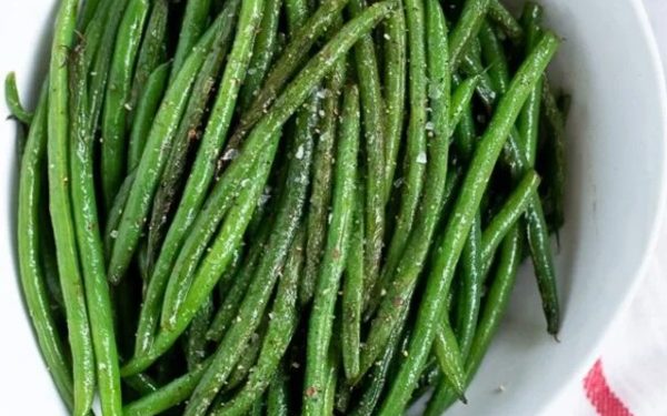 Haricot verts on a white plate.