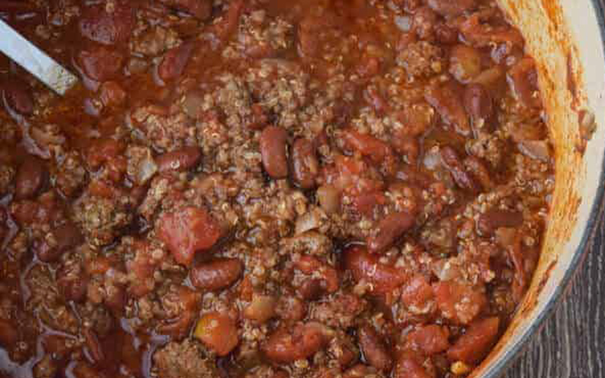 Chili with quinoa in an orange pot.