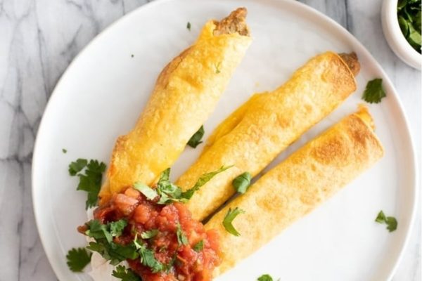 Taquitos on a white plate.