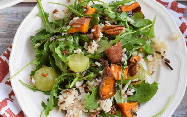 Wild rice salad with grapes and arugula on top.