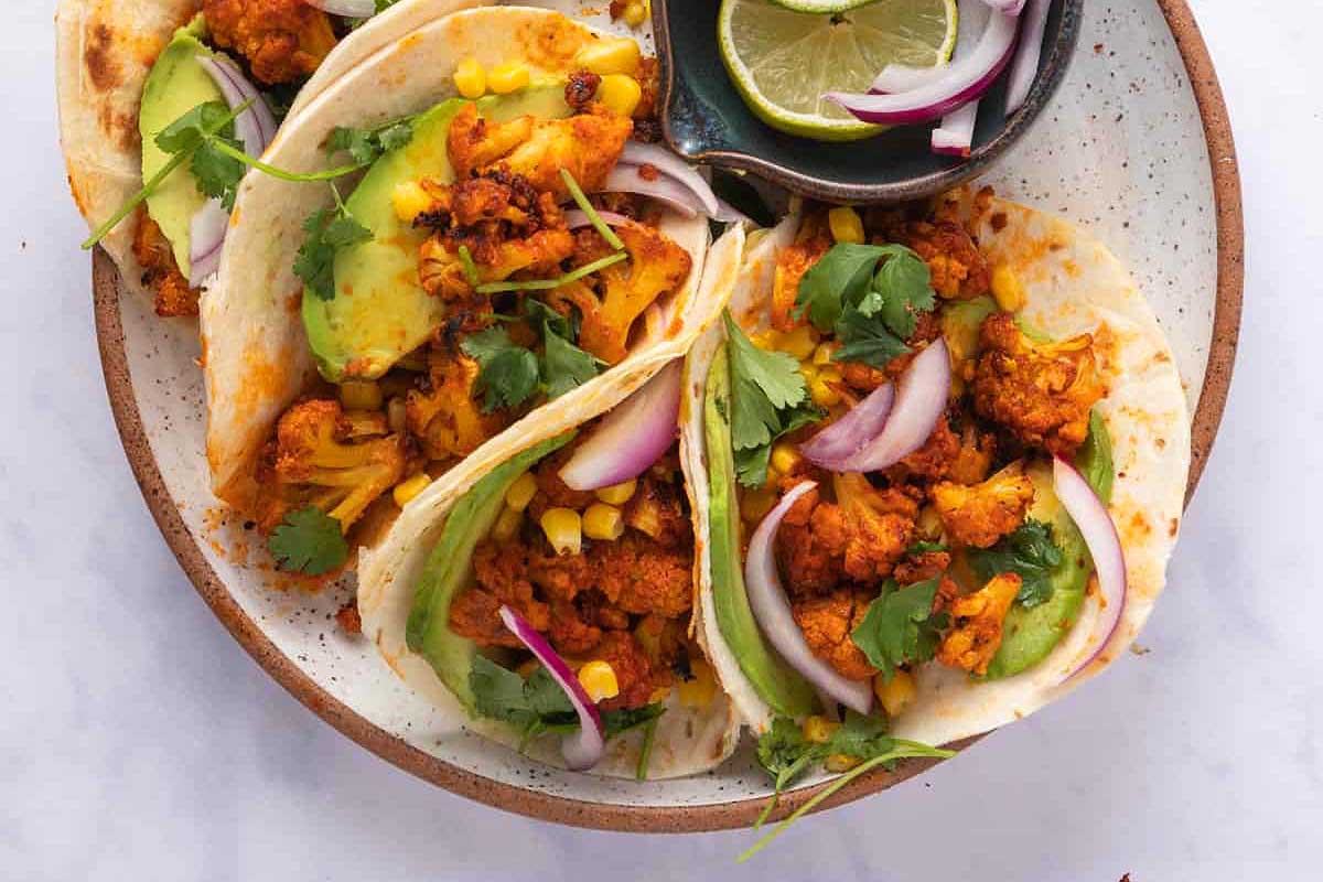 Cauliflower tacos on a white plate.