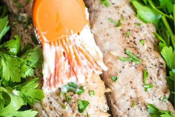 Basting Garlic Butter Pork Tenderloin with a brush. 