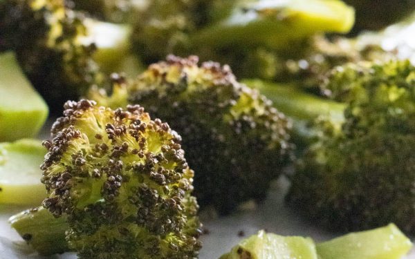 Roasted broccoli chopped on a plate.