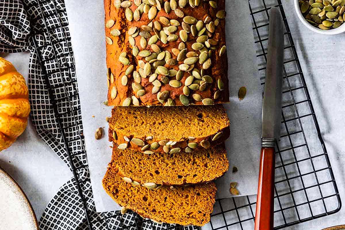 A slice of pumpkin bread on a cooling rack.