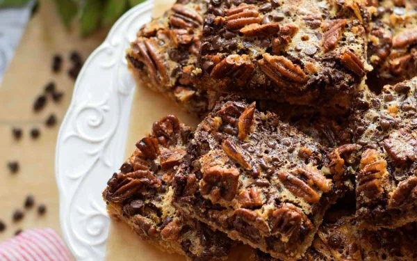Chocolate pecan bars on a white plate.
