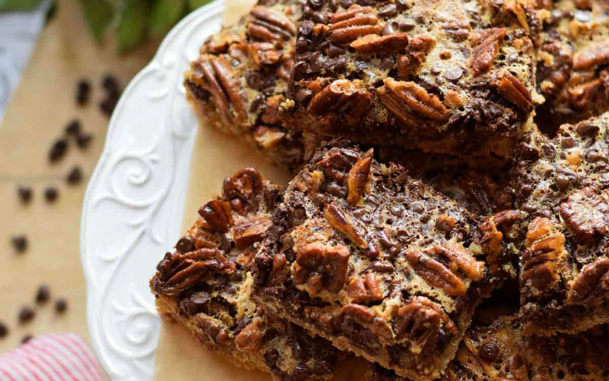 Chocolate pecan bars on a white plate.