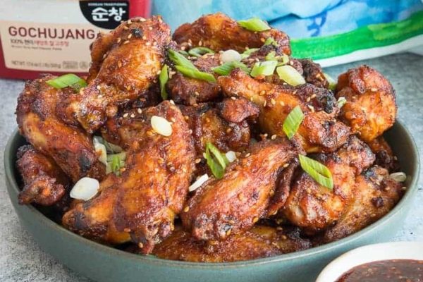 Sticky chicken wings in a blue bowl.