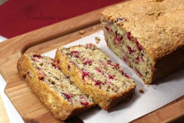 A slice of cranberry bread on a cutting board.