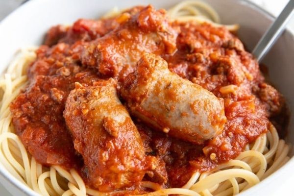 A bowl of spaghetti with meatballs and sauce.