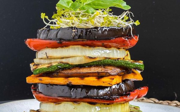 Stacked sliced vegetables of all colors.