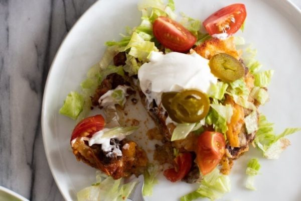 Enchiladas casserole with tomatoes on a plate.