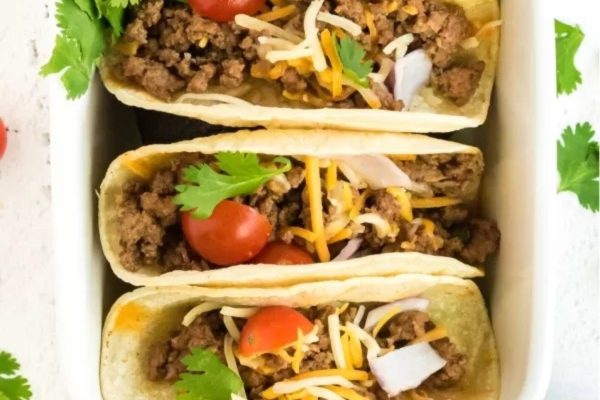 Three beef tacos in a white dish.