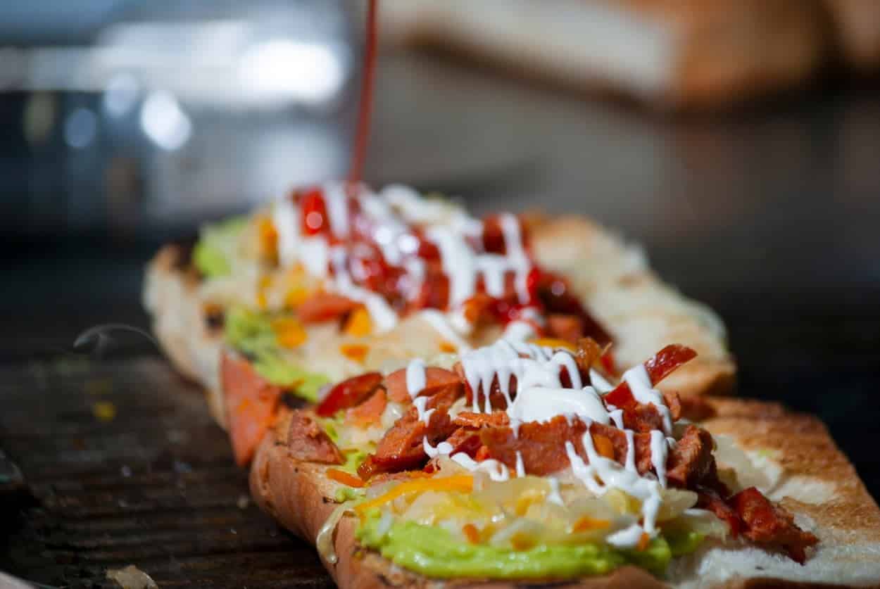 Guatemala’s Shucos on a grill with white sauce.