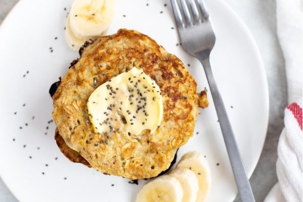 Baby Banana pancakes on a plate with banana slices.