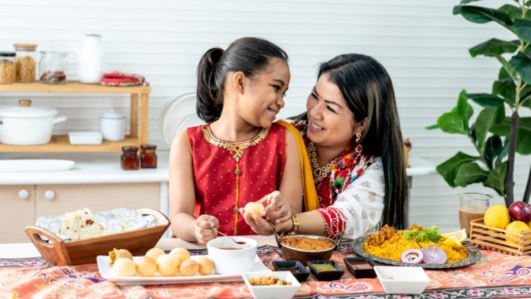 Indian mother and daughter in the kitchen cooking.