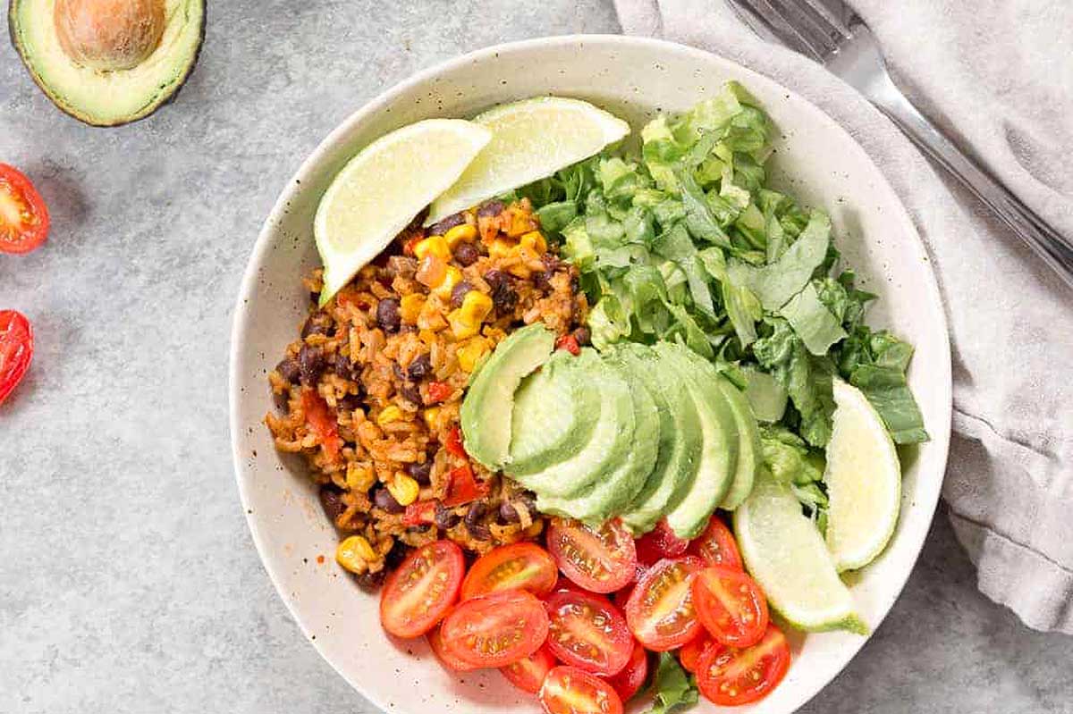 A bowl of black beans, tomatoes and avocado.