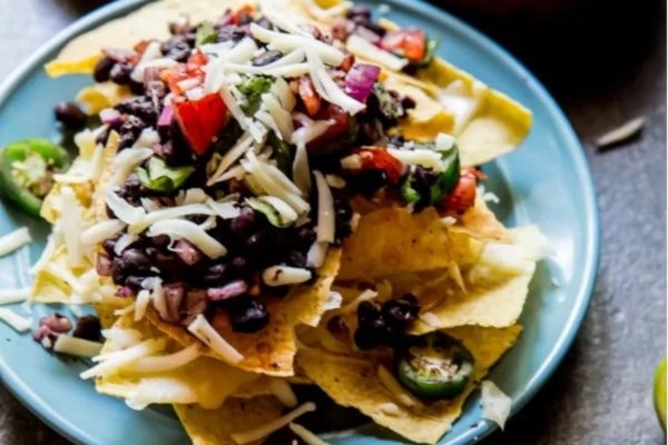 Mexican black bean nachos on a blue plate.