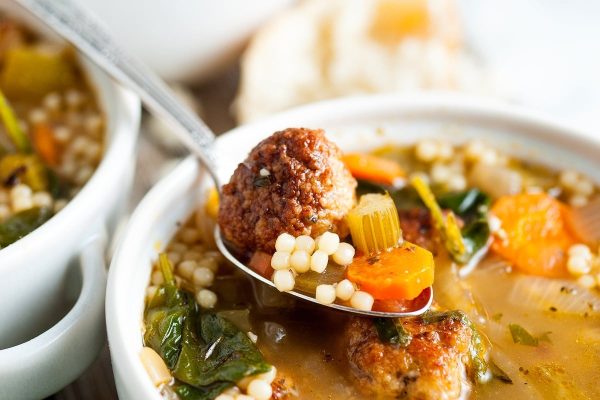 Italian wedding soup scooped out in a spoon.