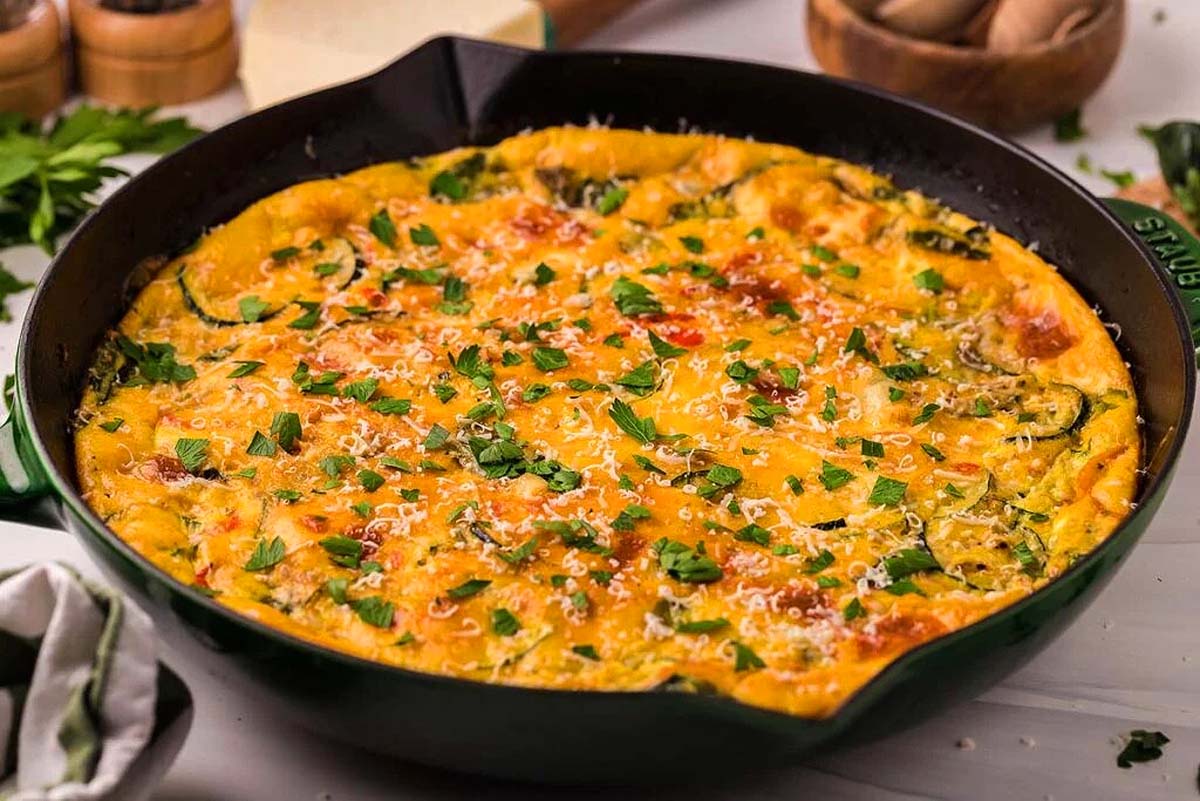 A skillet with a vegetable frittata in it.