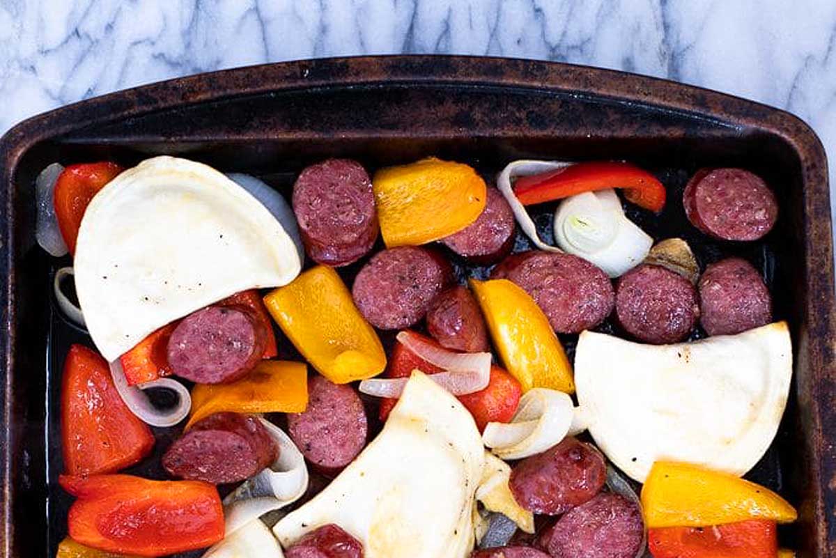 Sausage and peppers in a baking pan.