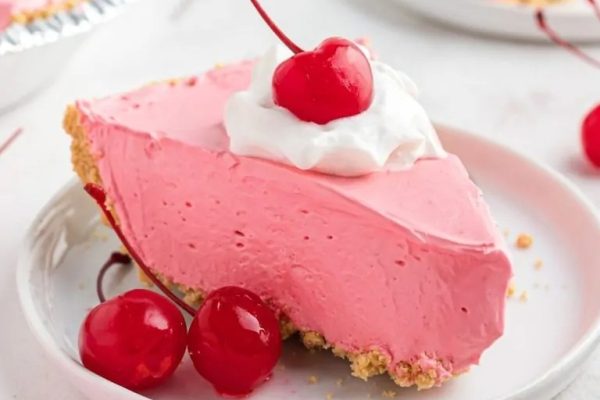 Kool Aid Pie topped with whipped cream and cherries. 