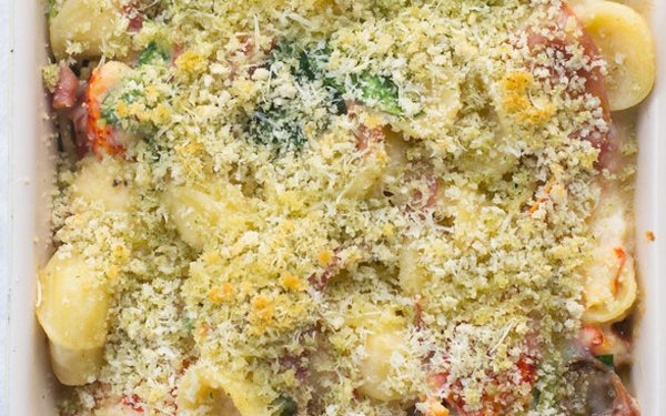 Lobster mac and cheese with breadcrumbs in a casserole dish.