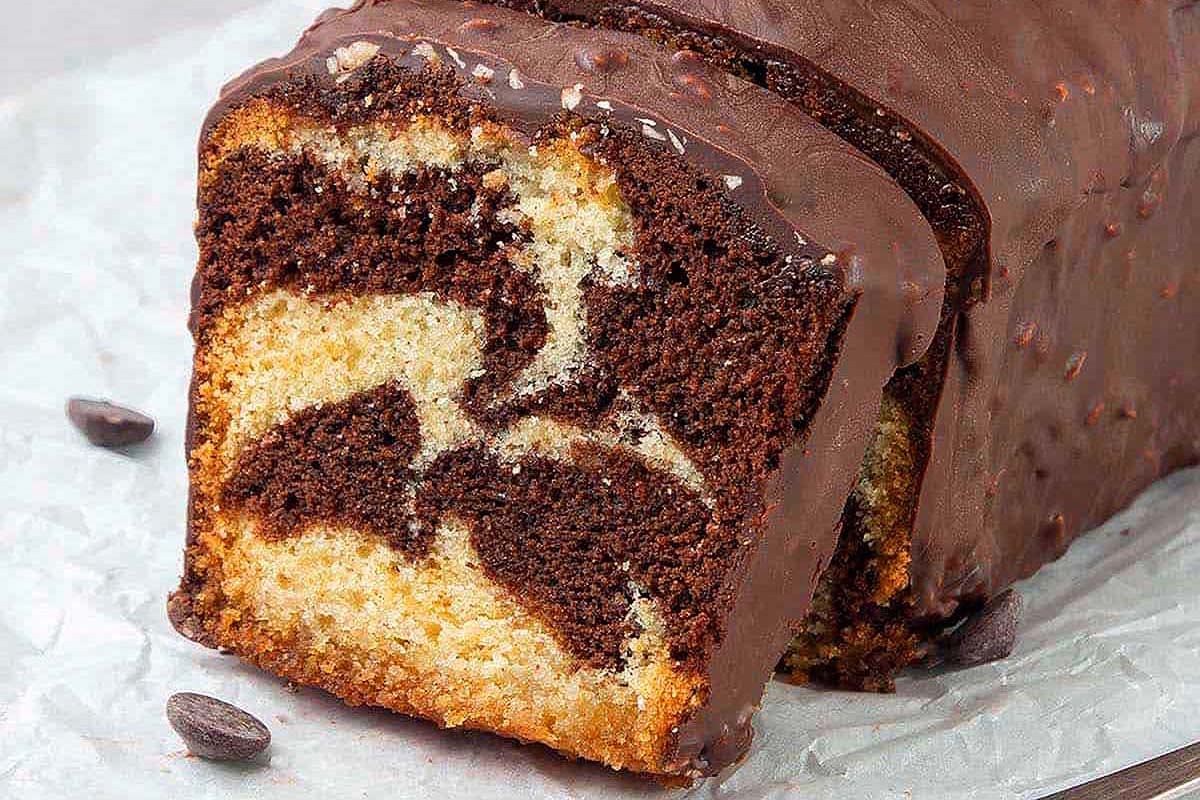 A slice of chocolate cake with chocolate chips on top.