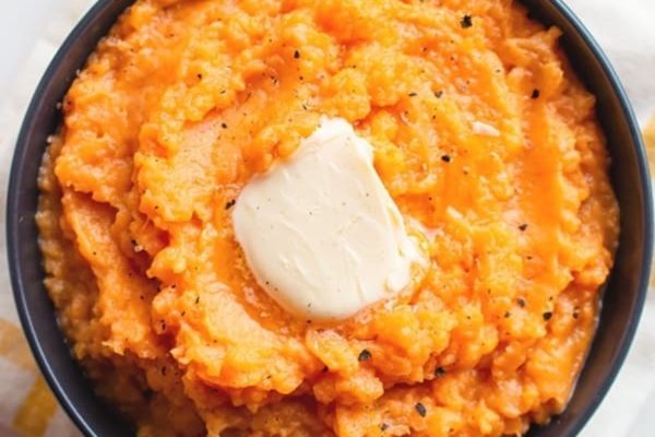 A serving of mashed sweet potato casserole with butter on top. 