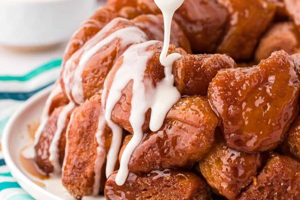 Monkey bread with a white sauce drizzled over it. 
