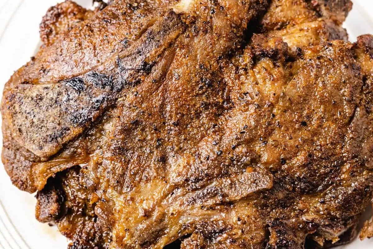 Pork chops in a baking dish with a creamy topping.