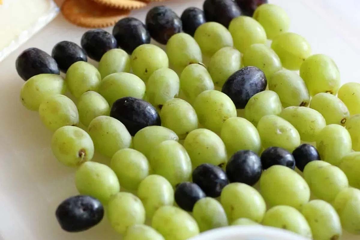 A fruit tray with grapes arranged to look like Frankenstein.