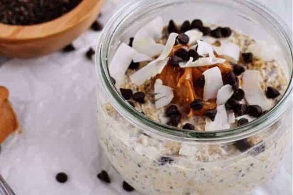 A jar of oatmeal with peanut butter and chocolate chips.