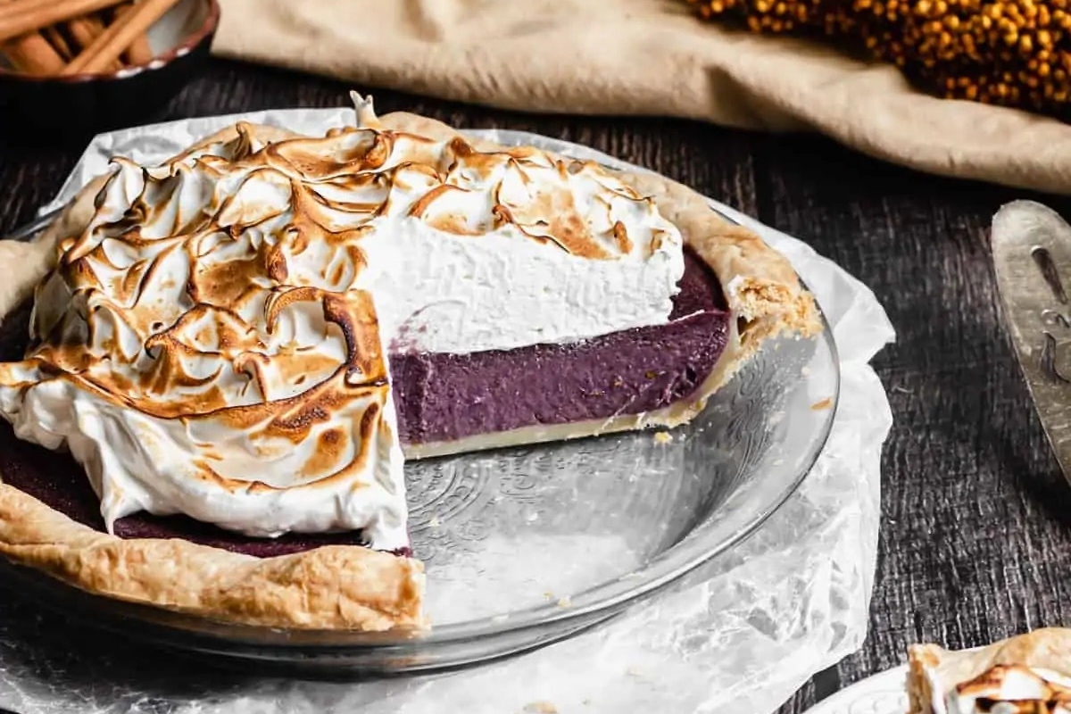 A delicious sweet potato pie with a slice taken out of it.