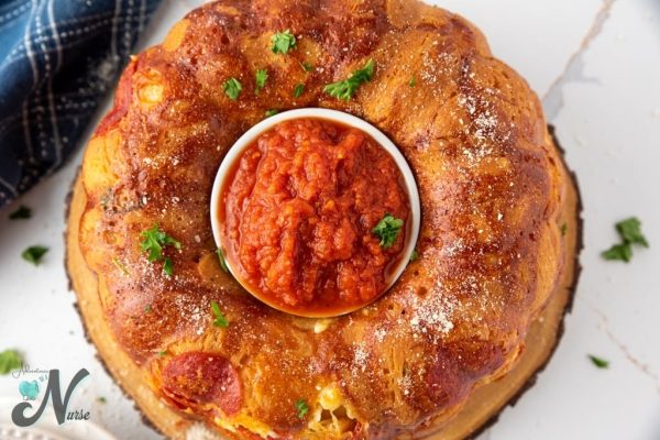Pizza monkey bread with a dish of tomato sauce in the middle.