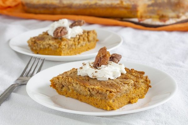 Two slices of pumpkin cake on plates.
