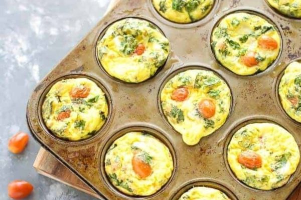 Quiche cups filled with tomato, proscuitto and kale, baked in muffin tins.
